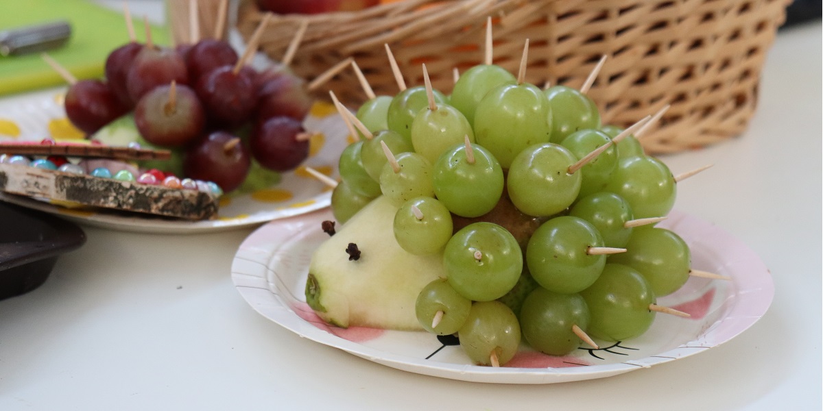 Ilustracja przedstawia jeża stworzonego z owoców.