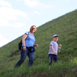 Zdjęcie przedstawia kobietę i chłopca wchodzących po ścieżce na kopiec.